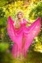 Fashion portrait of young beautiful girl posing against lilac bushes in blossom Royalty Free Stock Photo