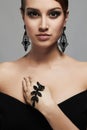 Fashion portrait of young beautiful woman in jewelry. elegant lady in black dress Royalty Free Stock Photo