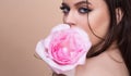 Fashion portrait of young beautiful woman with blue eyes and pink rose. Close-up portrait of a beautiful young girl with Royalty Free Stock Photo
