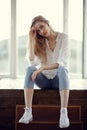 Fashion portrait of blonde woman. Jeans and sneakers.