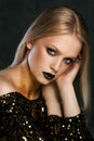 Fashion portrait of young caucasian model with golden sparkles on her neck.