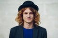 Fashion portrait of young reddish curly man