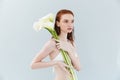 Fashion portrait of a young redheaded woman holding lily Royalty Free Stock Photo