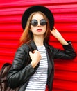 Fashion portrait young woman in black rock style stands over red