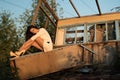 Fashion portrait of young woman, in an old house, in ruin, sitting