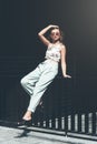 Fashion portrait of young woman wearing sunglasses, top, slingbacks, blue suit. Young beautiful happy model posing near