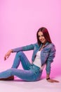 Fashion positive young woman in white classic T-shirt in denim blue jacket in stylish jeans posing and charming smiling in the