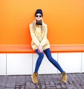 Fashion pretty blonde girl in city over orange background Royalty Free Stock Photo