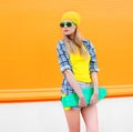 Fashion pretty blonde girl with skateboard over colorful orange Royalty Free Stock Photo