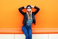 Fashion pretty blonde woman in rock black style posing on colorful orange background Royalty Free Stock Photo