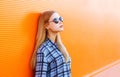 Fashion pretty blonde woman in sunglasses over colorful orange Royalty Free Stock Photo