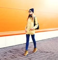 Fashion pretty blonde woman walking in city over orange colorful Royalty Free Stock Photo