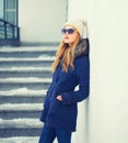 Fashion pretty blonde woman wearing a jacket hat in winter city Royalty Free Stock Photo