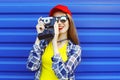 Fashion pretty cool girl wearing a colorful clothes with retro camera shooting Royalty Free Stock Photo