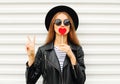 Fashion pretty cool young girl with red lollipop heart wearing black hat leather jacket over white urban Royalty Free Stock Photo