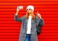 Fashion pretty cool young girl takes a picture self portrait on a smartphone Royalty Free Stock Photo