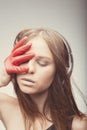 Fashion pretty girl listening music with headphones, wearing red gloves, cover face with it, take pleasure with song. Lifestyle Royalty Free Stock Photo