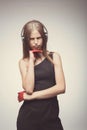 Fashion pretty girl listening music with headphones, wearing red gloves, and disappointed with bad music. Lifestyle woman concept Royalty Free Stock Photo