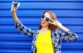 Fashion pretty woman in colorful clothes having fun makes self-portrait on the smartphone Royalty Free Stock Photo