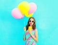 Fashion pretty woman drinks fruit juice from cup holds an air colorful balloons Royalty Free Stock Photo