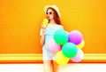 Fashion pretty woman drinks a fruit juice holds an air colorful balloons Royalty Free Stock Photo