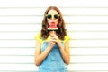 Fashion pretty woman eating a slice of watermelon in the form of ice cream on white background