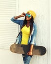 Fashion pretty young african woman with skateboard Royalty Free Stock Photo