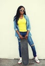 Fashion pretty young african woman with skateboard Royalty Free Stock Photo