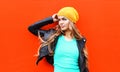 Fashion pretty young blonde woman wearing jacket hat looking in profile over colorful red Royalty Free Stock Photo
