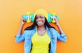 Fashion pretty young smiling african woman with skateboard in colorful clothes Royalty Free Stock Photo
