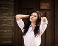 Fashion pretty young woman posing near a old wooden wall. Royalty Free Stock Photo