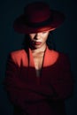 Fashion, red suit with spotlight for woman in dark, mystery and 90s retro on a black studio background. Designer, power Royalty Free Stock Photo