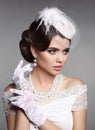 Fashion Retro elegant woman portrait. Wedding hairstyle. Brunette bride model present white hat, gloves and pearls jewelry access Royalty Free Stock Photo