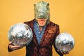 Fashion senior man wearing t-rex dinosaur mask while celebrating carnival holidays