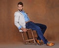 Fashion, serious and man in studio with trendy, stylish and classy suit on chair with confidence. Model, handsome and Royalty Free Stock Photo