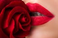 Fashion sexy woman with flowers. Vogue style model girl face with roses. Beautiful woman lips with rose. Royalty Free Stock Photo