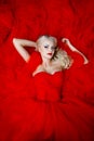 Fashion shoot of beautiful blond woman in a long red dress Royalty Free Stock Photo