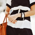 Fashion shoot of a blonde woman wearing a jewelry, and holding b