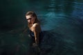 Fashion shoot of woman in long blue dress in water