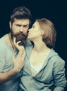 Fashion shot of couple after haircut. Barbershop concept. Woman on mysterious face with bearded man, black background Royalty Free Stock Photo