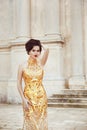 Fashion shot of stunning elegant woman in luxurious golden dress