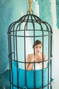 Fashion slave in captivity of beauty. prisoner woman in cage - home confinement. freedom of cute girl in cage chair Royalty Free Stock Photo