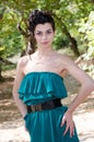 Fashion slim woman wearing green dress standing in the middle of a dirt road Royalty Free Stock Photo