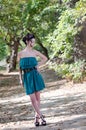 Fashion slim woman wearing green dress standing in the middle of a dirt road Royalty Free Stock Photo