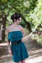 Fashion slim woman wearing green dress standing in the middle of a dirt road Royalty Free Stock Photo