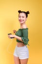 Fashion smiling asian woman listening to music in earphones ove Royalty Free Stock Photo