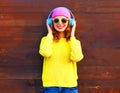 Fashion smiling girl listens to music in headphones, colorful pi Royalty Free Stock Photo