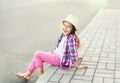 Fashion smiling little girl child wearing a checkered pink shirt and hat Royalty Free Stock Photo