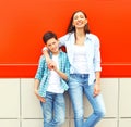 Fashion smiling mother with son teenager together on red Royalty Free Stock Photo