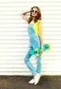 Fashion smiling woman holds a skateboard posing over a white Royalty Free Stock Photo